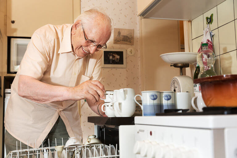 senior man unloading dishwasher at Independent Living for Seniors