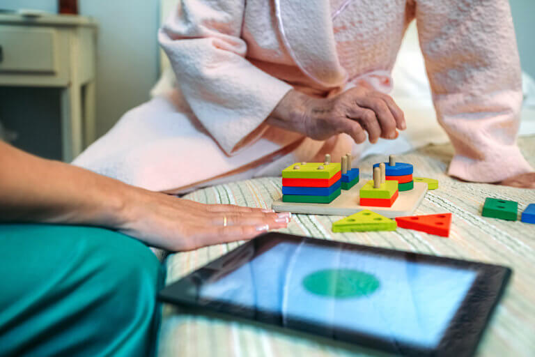 senior woman with nurse doing memory care activity