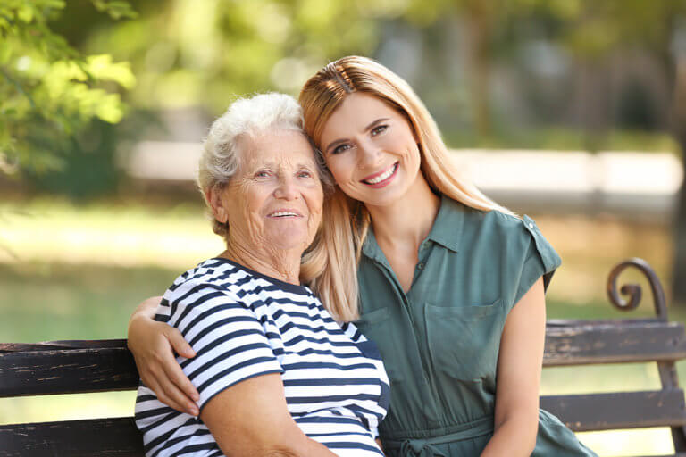 woman with elderly mother smiling knowing when her parent needs assisted living