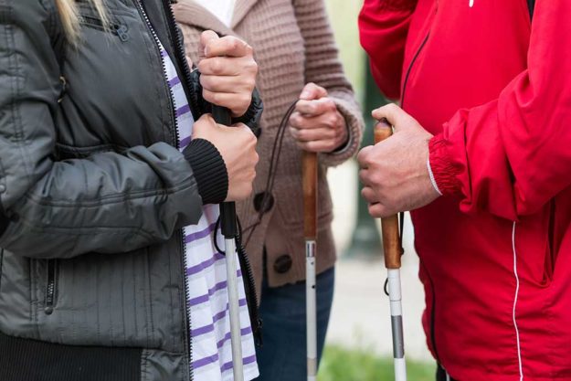 Close up in blind woman’s hands holding a stick Close up in blind woman's hands holding a stick. Selective focus image with shallow depth of field
