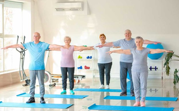 Elderly people exercising in gym