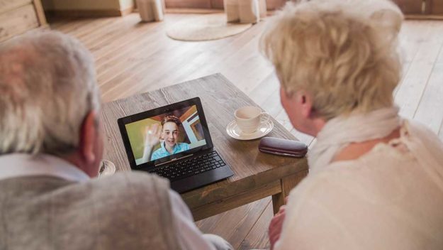 Grandchild over video call wave to grandparents Grandchild over video call wave to grandparents