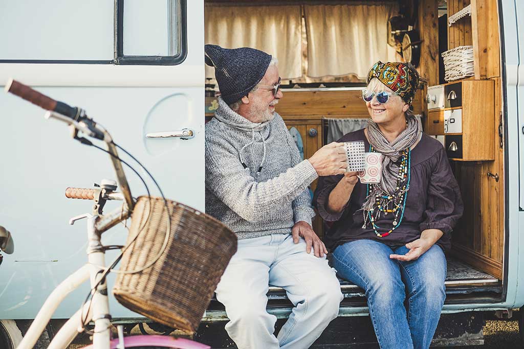 Happy cheerful mature people couple caucasian traceler enjoy and take a break resting sit down out of her van
