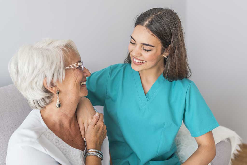 Nurse Talking With Senior Woman Sitting In Chair On Home Visit Nurse Talking With Senior Woman Sitting In Chair On Home Visit. Female Community Nurse Visits Senior Woman At Home. Female Support Worker Visits Senior Woman