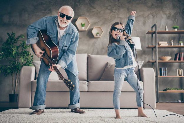 Photo of two people funky grandpa play guitar small nice granddaughter mic singing cool style