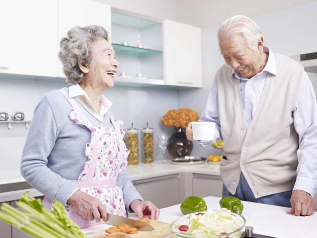senior couple in kitchen senior asian couple talking and laughing in kitchen.
