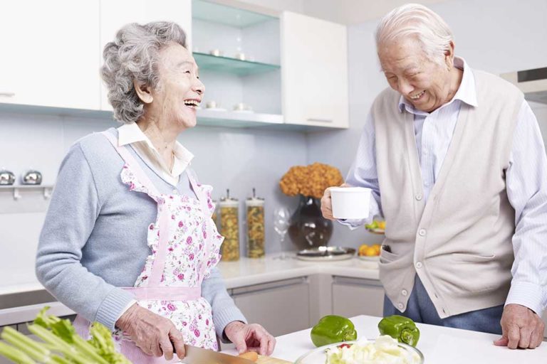 senior couple in kitchen senior asian couple talking and laughing in kitchen.
