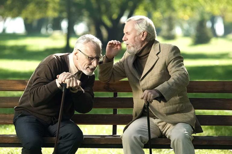 Senior gentlemen talking to his hearing impairment old friend, h Senior gentlemen talking to his hearing impairment old friend, health problems