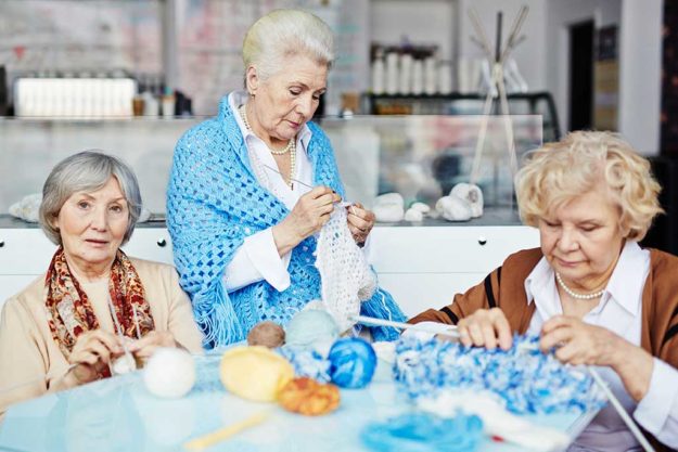 Three pretty elderly women gathered together in living room