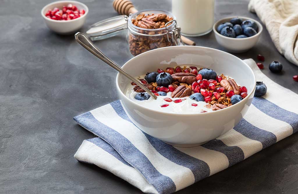 Granola, muesli with pomegranate seeds, blueberries and yogurt