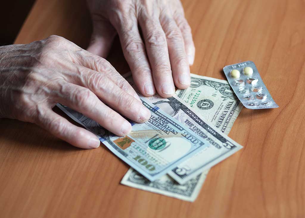 Medicines and money in the hands of a pensioner.
