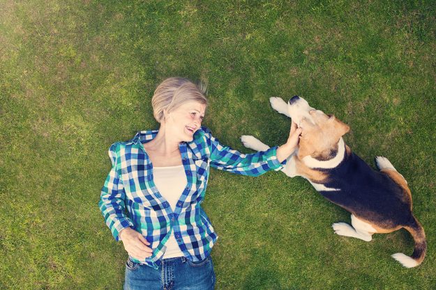 Beautiful senior woman lying on a grass in a park