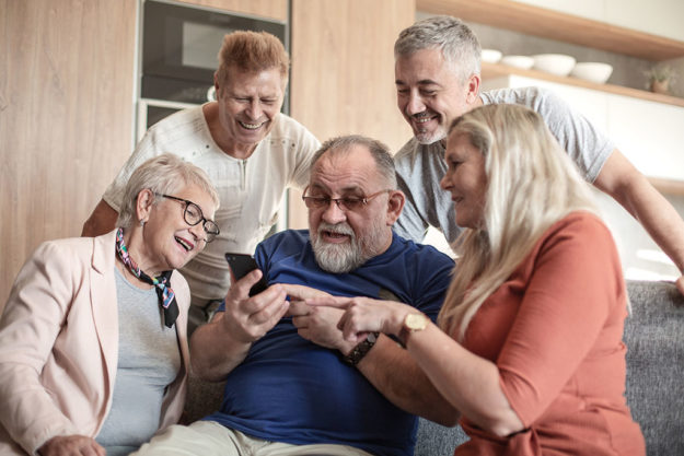 Mature friends looking at the smartphone screen.