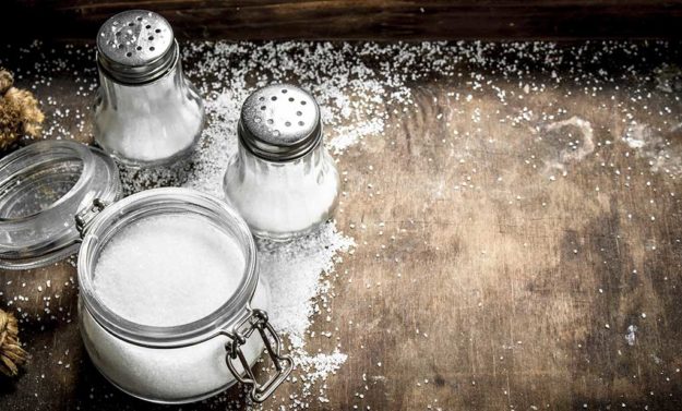 Salt in glass jar on a wooden table. Salt in glass jar on a wooden table.