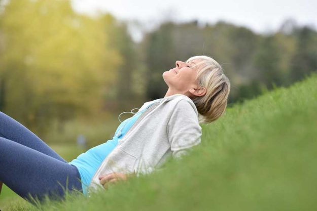 Senior woman in fitness outfit relaxing in park Senior woman in fitness outfit relaxing in park