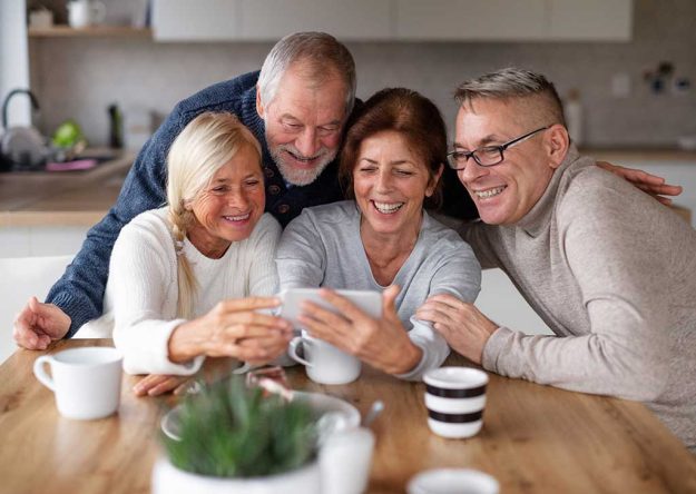 Group of senior friends at home, taking selfie. How To Reconnect With Your Old Friends