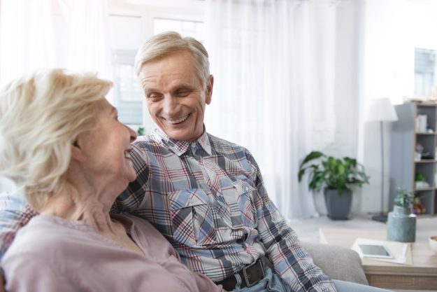 Cheerful pensioners sitting in embrace