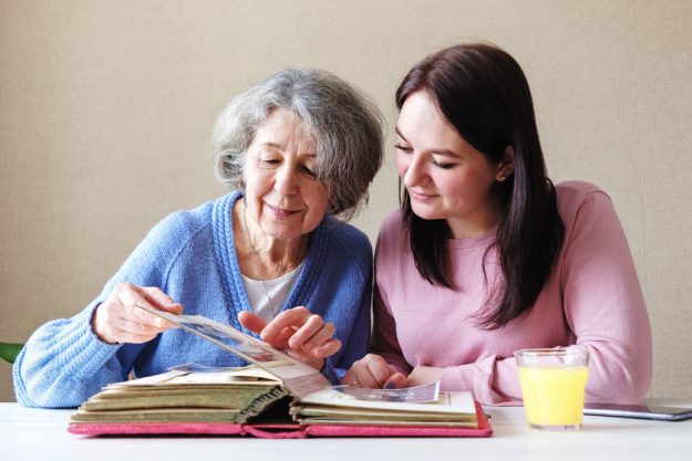 Grandmother and daughter watching a family album with old photos Grandmother and daughter watching a family album with old photos