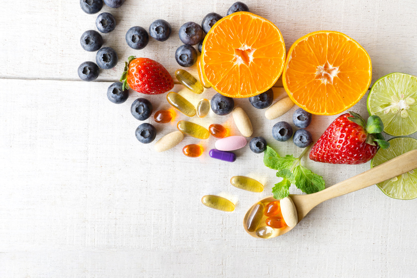 Multivitamins and supplements with fresh and healthy fruits on w
