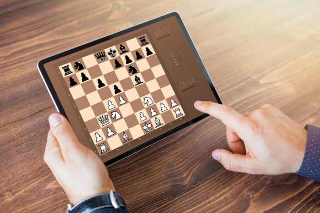 Man playing chess online on tablet computer 6 Online Activities For Your Loved One With Dementia