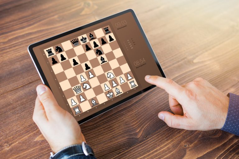 Man playing chess online on tablet computer 6 Online Activities For Your Loved One With Dementia