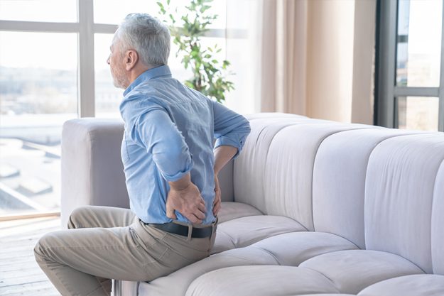 Senior caucasian old elderly man suffering from back pain at home. Senior caucasian old elderly man suffering from back pain at home.