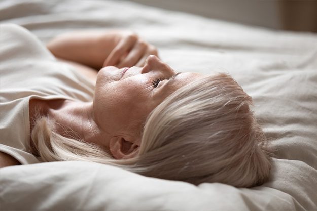 Tired mature woman relax sleeping in comfy bed
