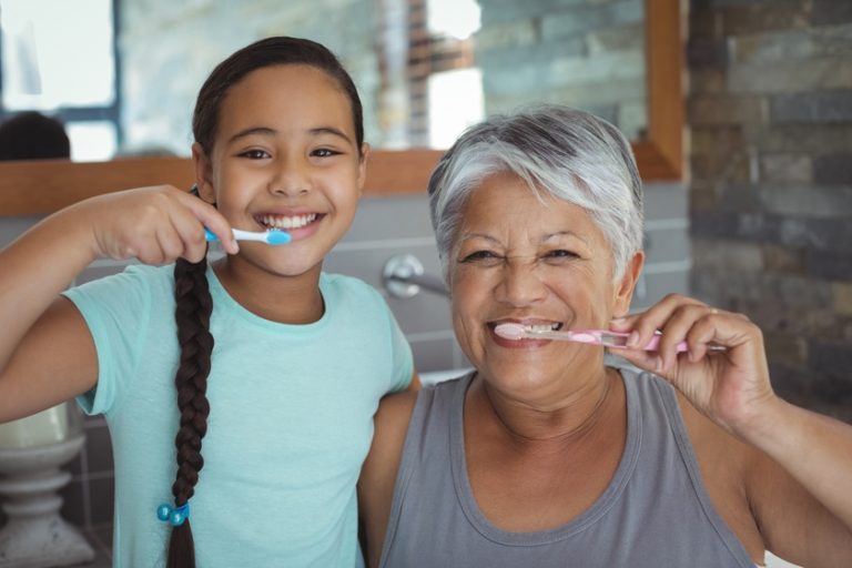 Grandmother and granddaughter brushing teeth in the bathroom Why Do You Need To Improve Your Oral Health As You Age?