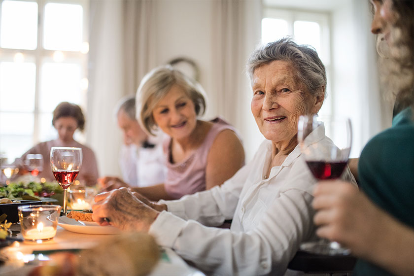 An elderly women with a family sitting at a table