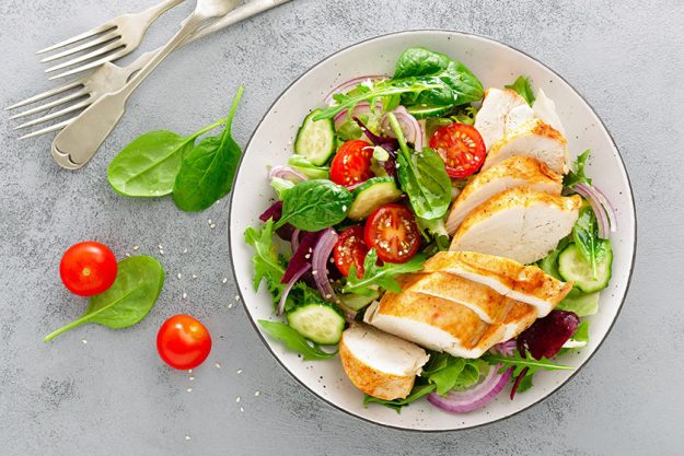 Grilled chicken breast, fillet and fresh vegetable salad of lettuce, arugula, spinach, cucumber and tomato. Grilled chicken breast, fillet and fresh vegetable salad of lettuce, arugula, spinach, cucumber and tomato.