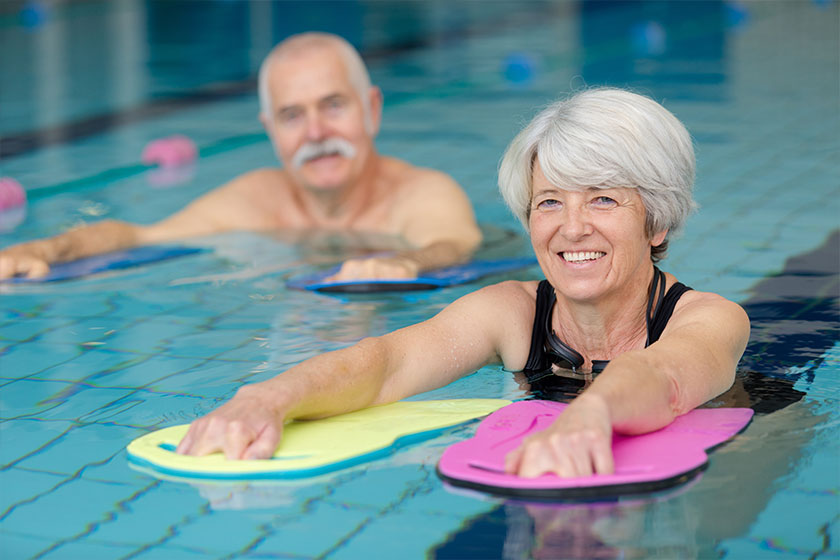 happy senior couple taking swimming lessons happy senior couple taking swimming lessons