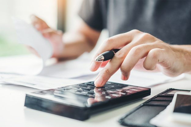 Man using calculator Accounting Calculating Cost