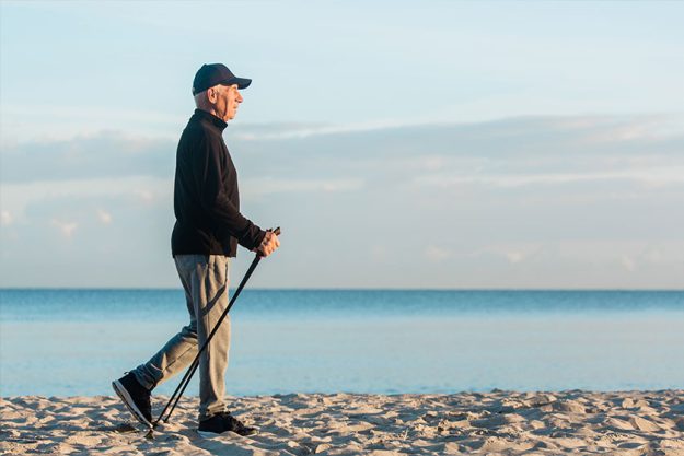 Nordic walking – senior man working out on beach. Healthy lifestyle Nordic walking - senior man working out on beach. Healthy lifestyle