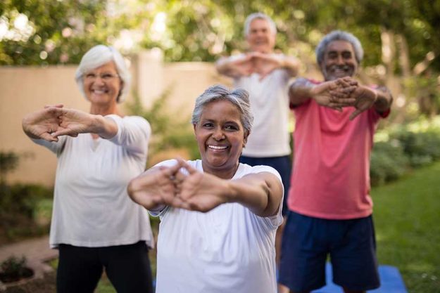 Portrait of senior woman stretching arms with friends Portrait of senior woman stretching arms with friends