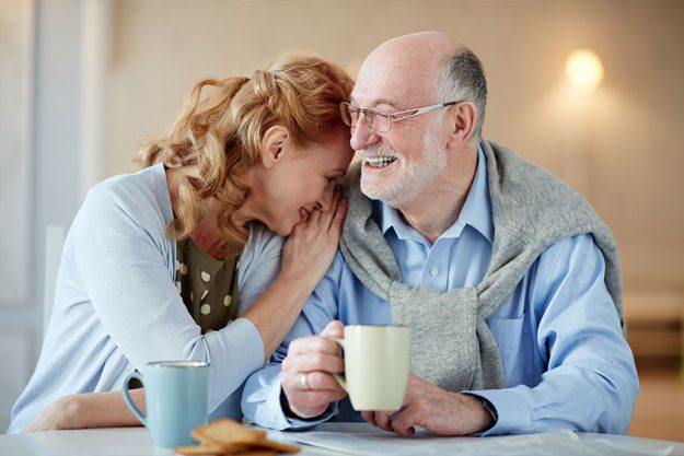 Portrait of smiling senior couple sitting close together Portrait of smiling senior couple sitting close together