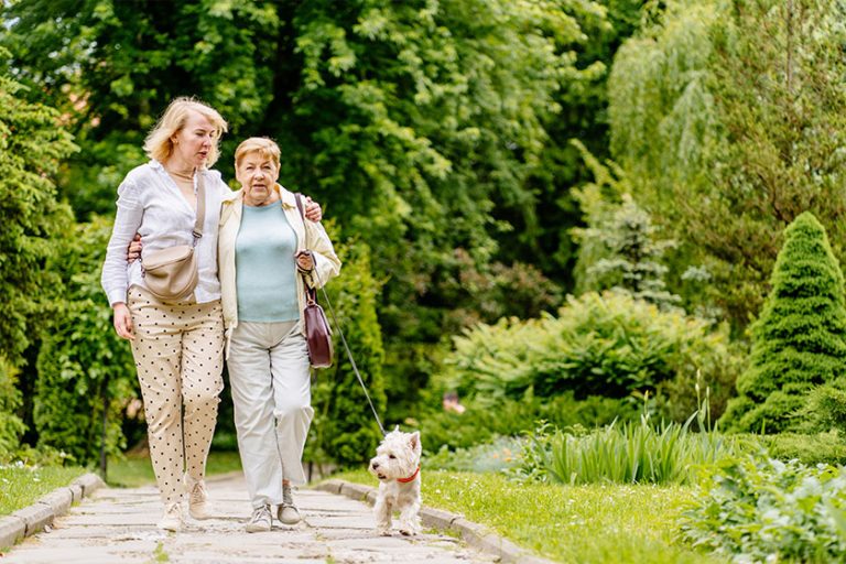 Senior mother and adult mature daughter with cute pet dog