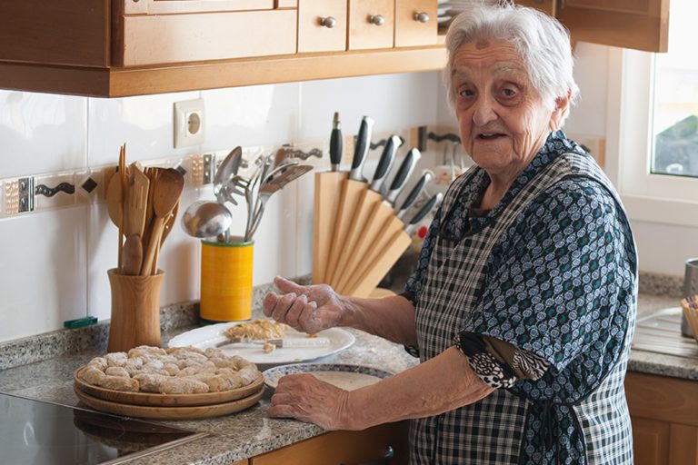 Elderly woman preparing croquettes