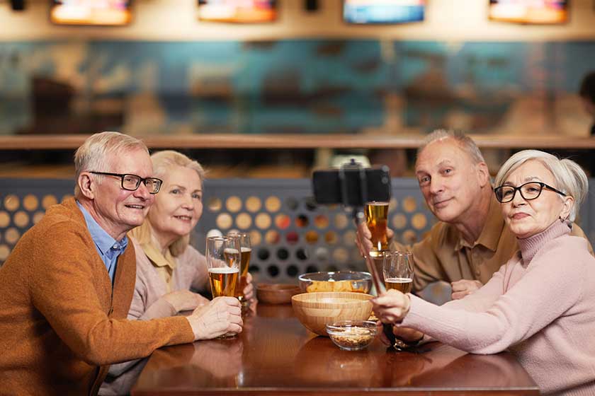 Group of modern senior people taking selfie photo while drinking beer