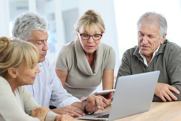 Group of retired senior people using laptop and tablet