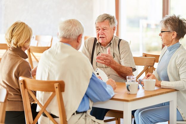 Gruppe Senioren als Freunde beim Karten spielen
