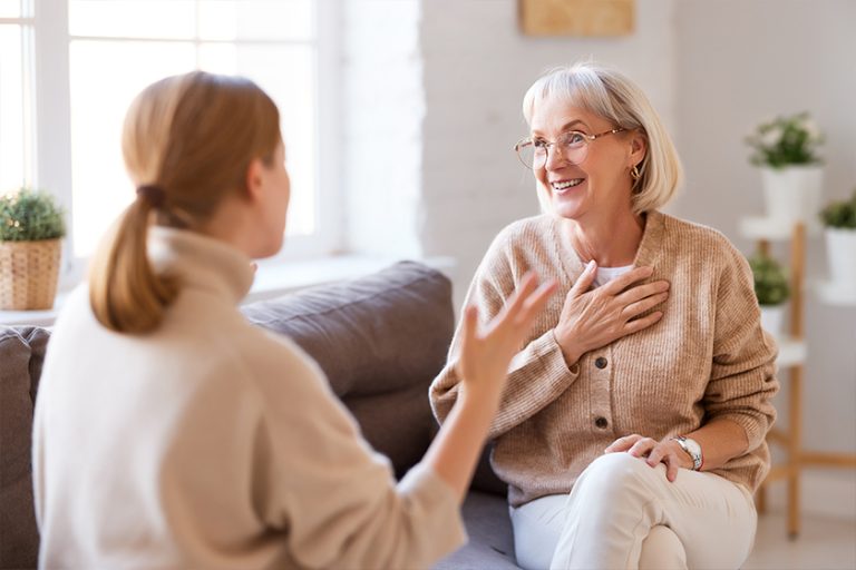 Happy women chatting on sofa at home.