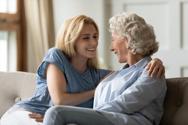 Loving grown up adult daughter hugs lovely elderly mother