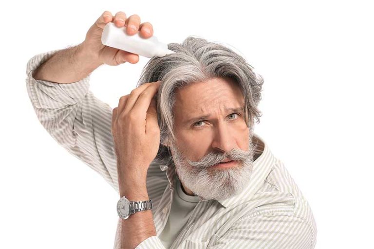 Mature man using serum for hair loss treatment