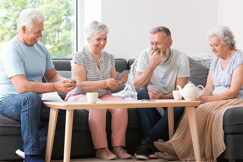Portrait of elderly people playing cards in nursing home
