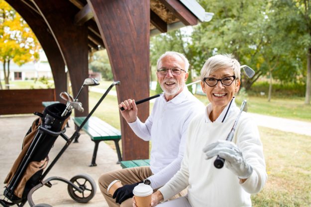 Portrait of senior people in retirement holding golf clubs and r Five Ways Senior Communities In Marco Island, FL Can Promote A Happy Retirement
