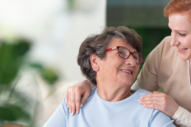 Close-up of a tender caregiver with her hands on the shoulders o Close-up of a tender caregiver with her hands on the shoulders o
