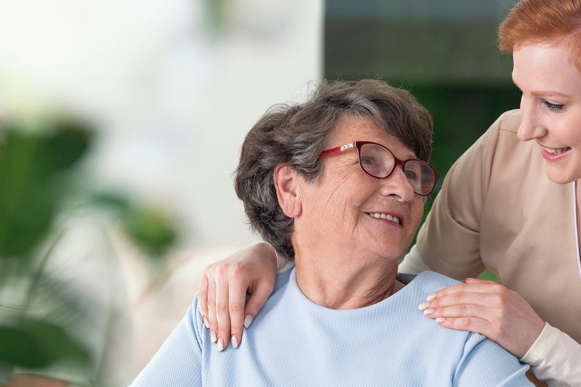 Close-up of a tender caregiver with her hands on the shoulders o Close-up of a tender caregiver with her hands on the shoulders o