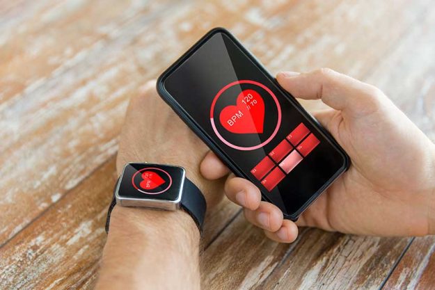 close up of hands with smart phone and watch