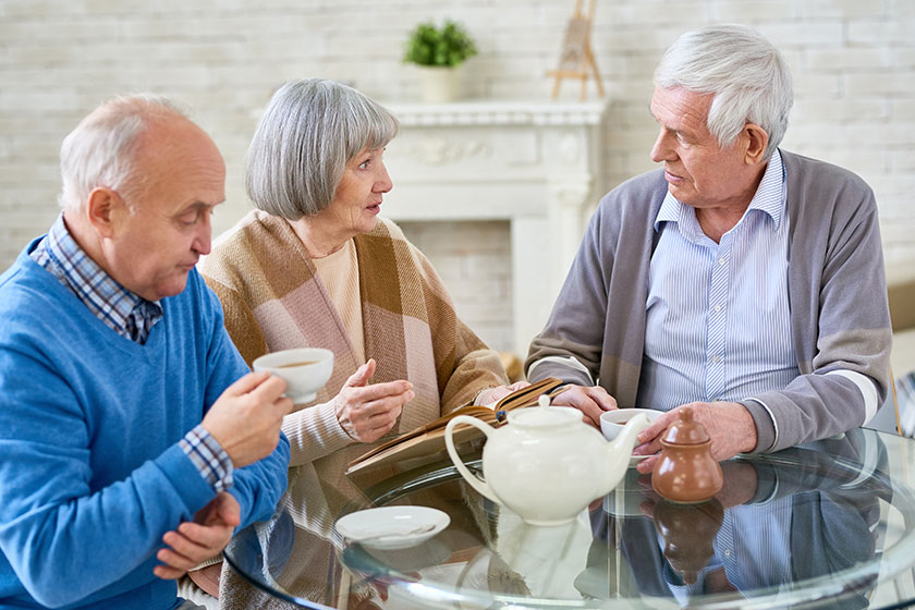 Group of elderly woman and men having teatime at table Group of elderly woman and men having teatime at table