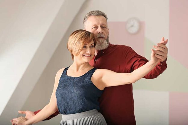 Happy mature couple dancing at home Happy mature couple dancing at home